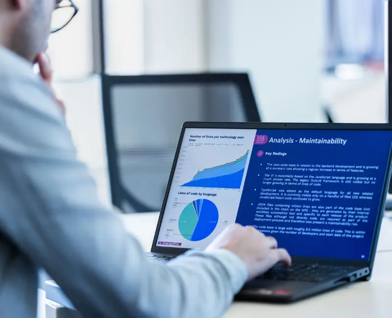 Persona revisando gráficos y análisis en un ordenador portátil, ilustrando la elaboración de un informe de Tech Due Diligence para inversores